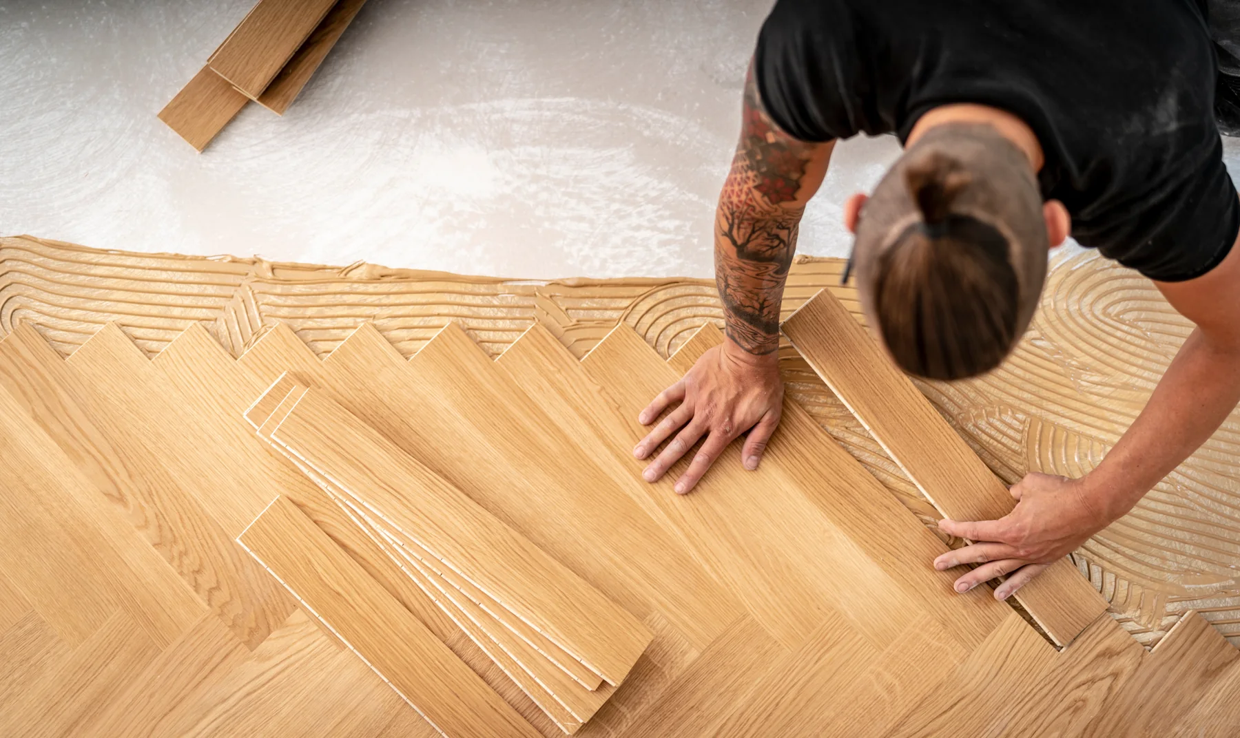 Handwerker verlegt Holzdielen auf einer vorbereiteten Fläche