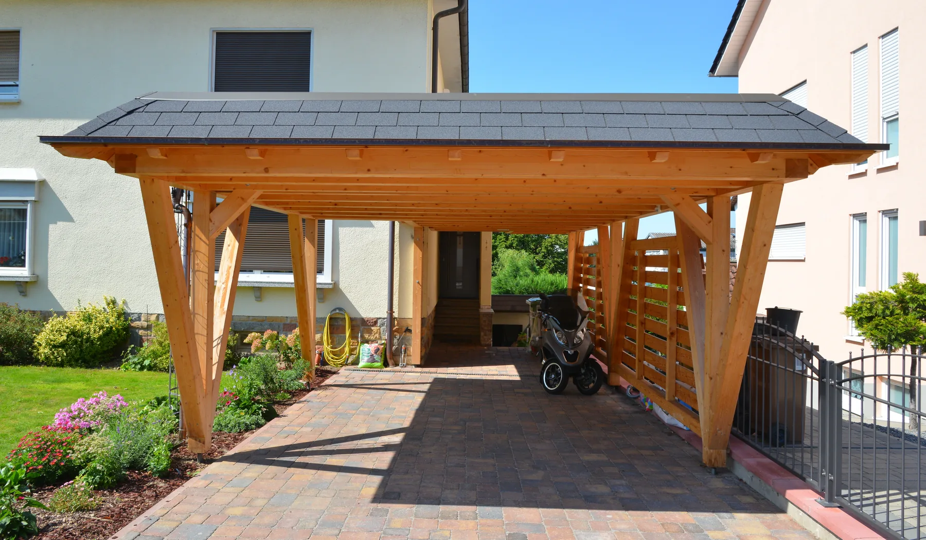 Holzcarport am Wohnhaus Holzcarport an einem Wohnhaus mit gepflasterter Zufahrt
