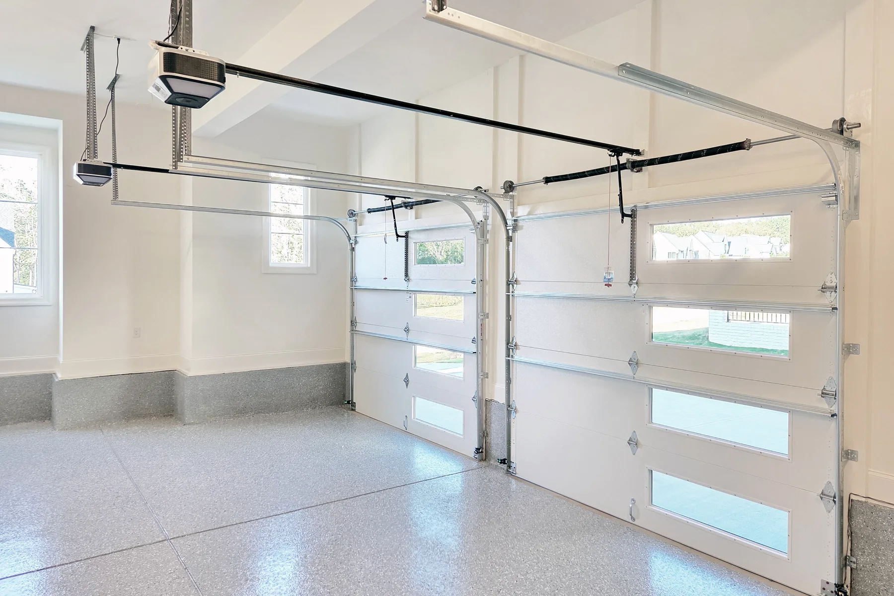 Garageninnenraum mit Toren Heller Innenraum einer Garage mit zwei Sektionaltoren