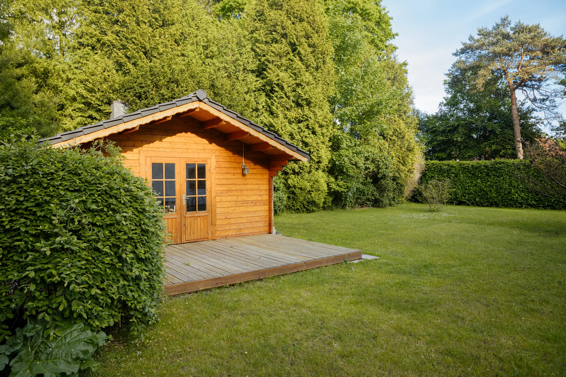 Gartenhaus aus Holz Kleines Gartenhaus aus Holz mit angrenzender Terrasse
