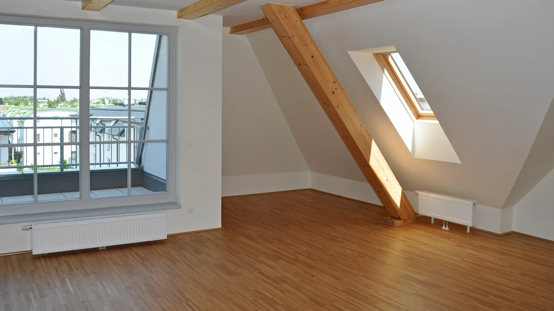 Fertiger Dachraum Helles fertig ausgebautes Dachgeschoss mit Holzboden und sichtbaren Balken