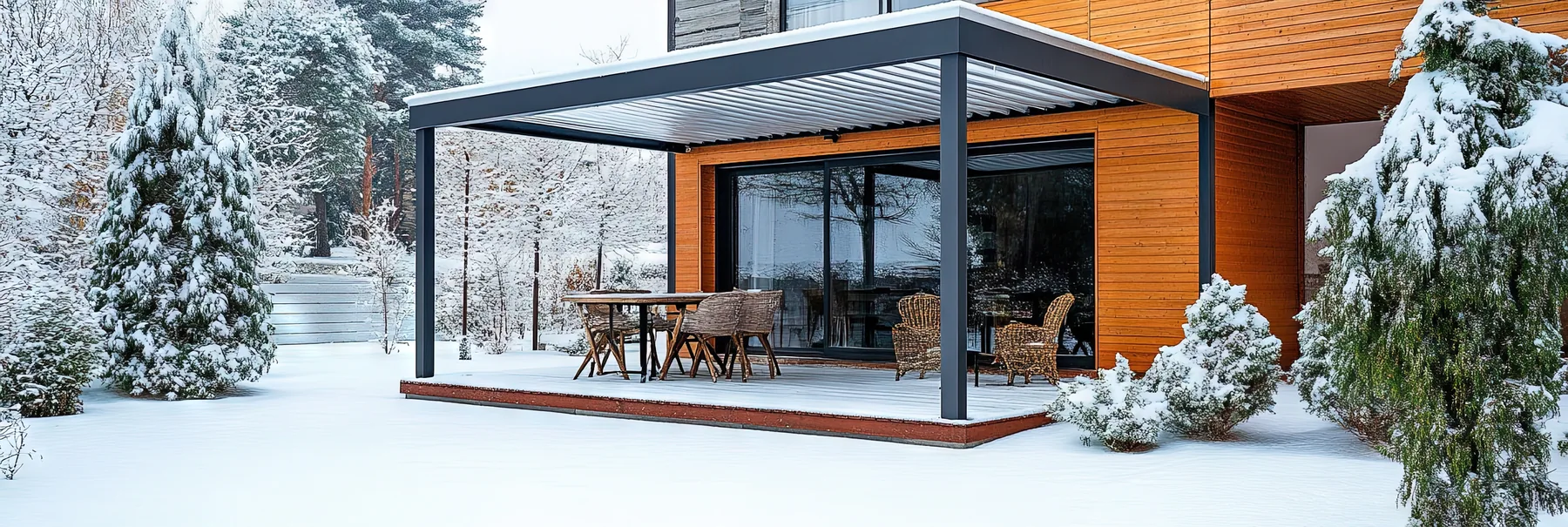 Überdachte Terrasse im Winter Offene Terrassenüberdachung an einem Wohnhaus im verschneiten Garten