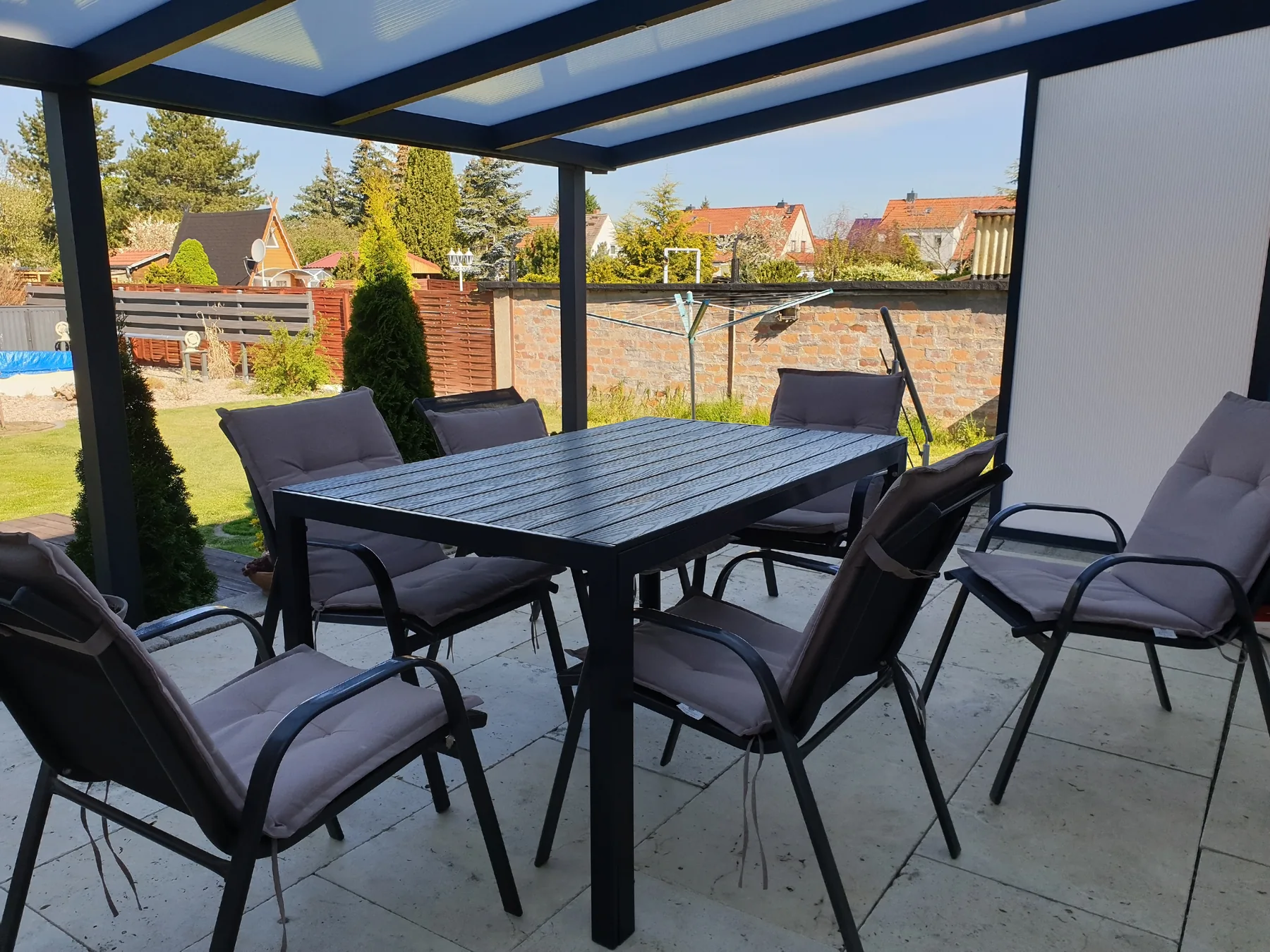 Terrassenüberdachung – Essplatz im Garten Essplatz mit Tisch und Stühlen unter einer Terrassenüberdachung