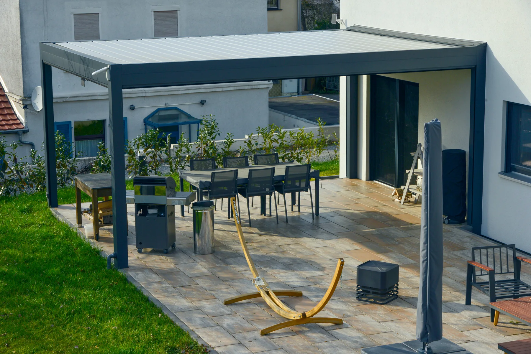 Terrassenüberdachung mit dunklem Dach Dunkle Überdachung über einem Essplatz auf der Terrasse