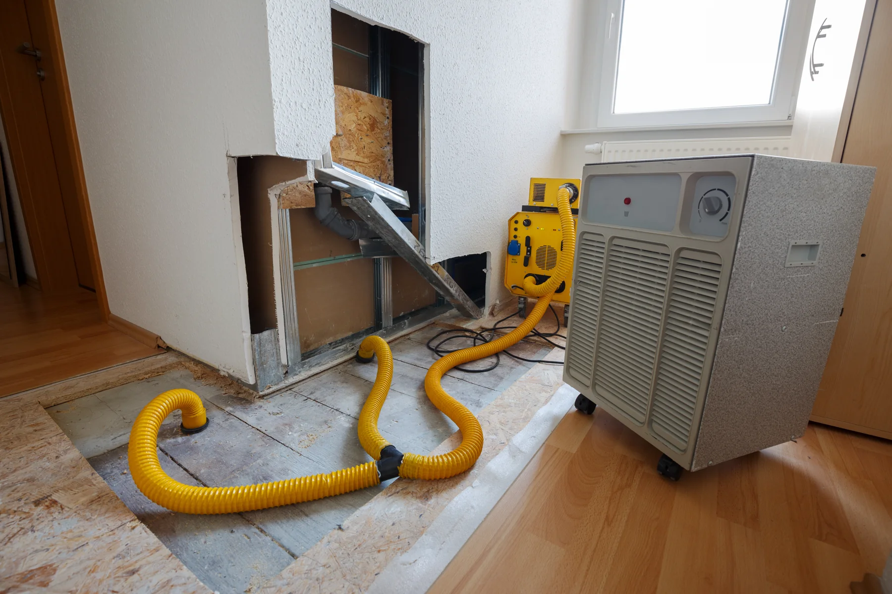 Trocknungsgerät mit Schläuchen in einem Wohnraum