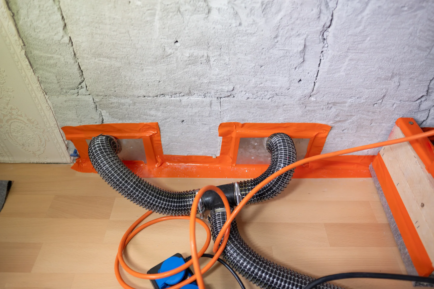 Schläuche für die Trocknung an einem geöffneten Wandsockel