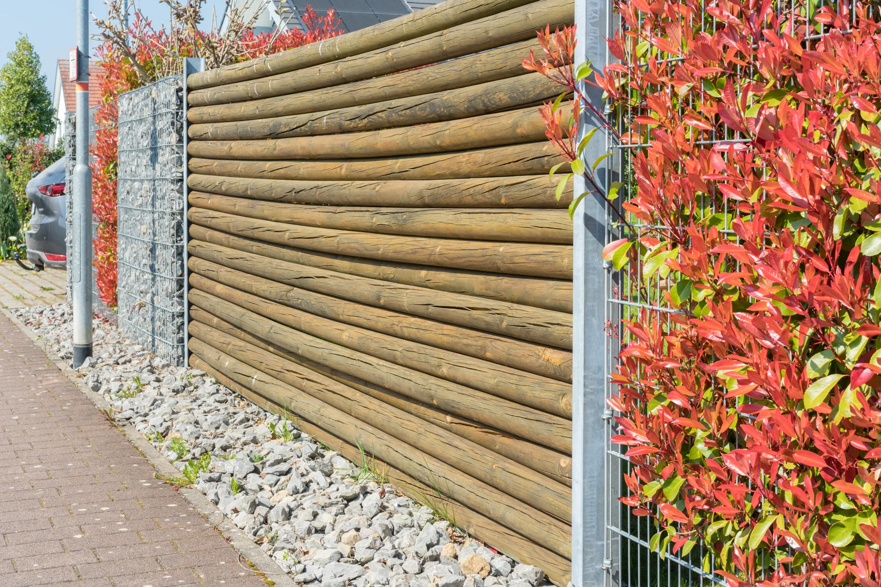 Holzsichtschutz zwischen Gabionen und bepflanzten Zaunfeldern